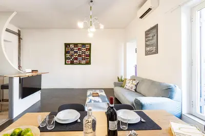 a living room with a table and a couch at Colosseo Apartment Holiday - Attico al Colosseo a Monti in Rome