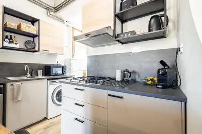 a kitchen with white cabinets and a stove top oven at Colosseo Apartment Holiday - Attico al Colosseo a Monti in Rome