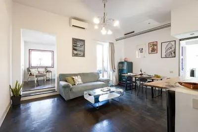 a living room with a couch and a table at Colosseo Apartment Holiday - Attico al Colosseo a Monti in Rome