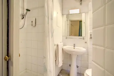 a white bathroom with a sink and a toilet at Hotel Primavera in Rome