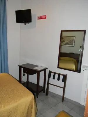 a bedroom with a table and a mirror and a chair at Hotel Primavera in Rome