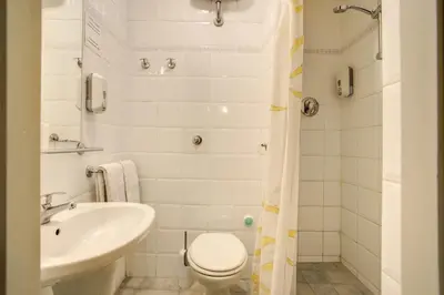 a white bathroom with a toilet and a sink at Hotel Primavera in Rome