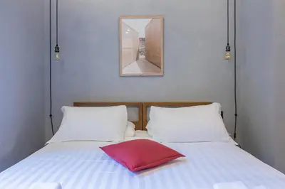 a red pillow sitting on a bed with two pillows at Pietra - The Italian Stay Collection in Rome