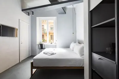 a bedroom with a white bed and a window at Pietra - The Italian Stay Collection in Rome