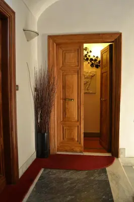 a hallway with a wooden door and a vase of plants at Hotel Al SanPietrino in Rome