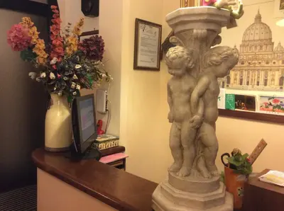 a statue of two children on a desk with a vase of flowers at Hotel Al SanPietrino in Rome