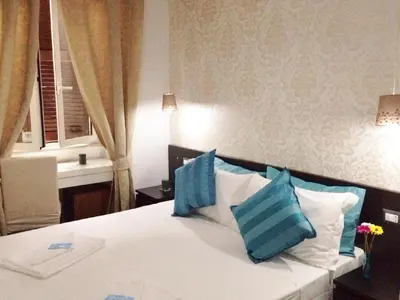 a bedroom with a bed with blue and white pillows at The Place In Rome Guest House in Rome