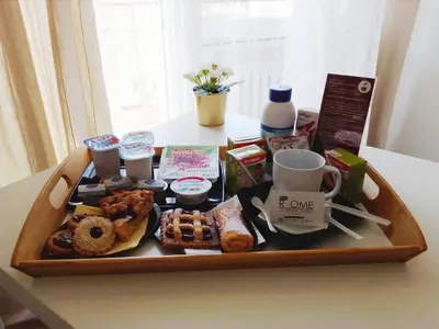 a tray of food on a table with coffee and pastries at Pianeta Roma 62 in Rome