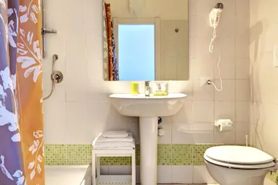 a bathroom with a sink and a toilet and a mirror at Pianeta Roma 62 in Rome