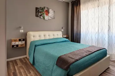 a bedroom with a bed with blue sheets and a window at Pianeta Roma 62 in Rome