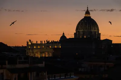 a dome of a building with birds flying in the sky at Hotel Relais Dei Papi in Rome