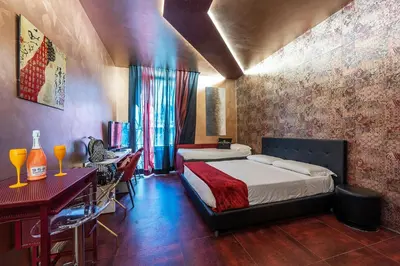 a bedroom with a bed and a table and a desk at Hotel Relais Dei Papi in Rome