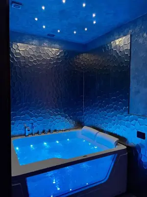 a blue bath tub in a room with a stone wall at Hotel Relais Dei Papi in Rome