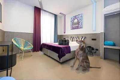 a dog sitting in a bedroom with a bed at Hotel Relais Dei Papi in Rome