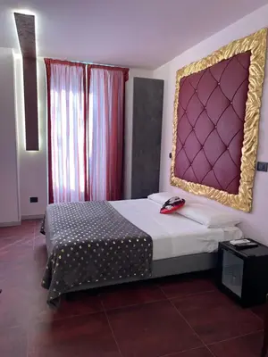 a bedroom with a bed with a large headboard at Hotel Relais Dei Papi in Rome