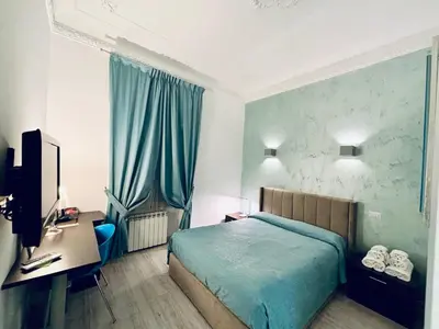 a bedroom with a bed and a desk with a computer at Chroma Italy - Chroma Tessera in Rome