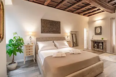 a bedroom with a large bed and a fireplace at Palazzo storico Dormo da Lisa - Colosseo in Rome