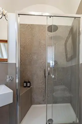 a shower with a glass door in a bathroom at Palazzo storico Dormo da Lisa - Colosseo in Rome