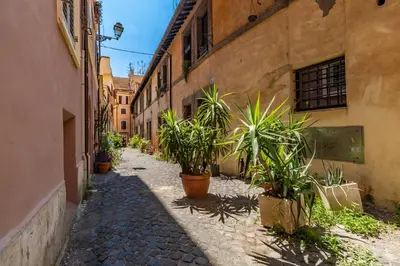 an alley with potted plants in an old building at Palazzo storico Dormo da Lisa - Colosseo in Rome