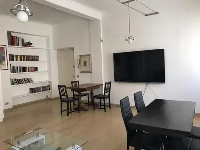 a living room with a table and chairs and a tv at Arches B&B in Rome