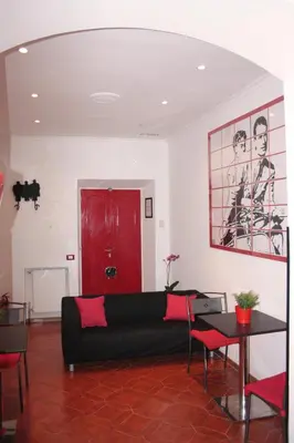 a living room with a black couch and a red door at Arches B&B in Rome
