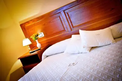 a bedroom with a bed with a wooden head board at Relais Cavour in Rome