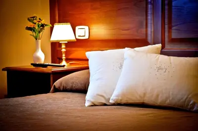 a bed with white pillows and a table with a lamp at Relais Cavour in Rome