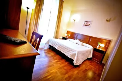 a hotel room with a bed and a desk and a desk at Relais Cavour in Rome