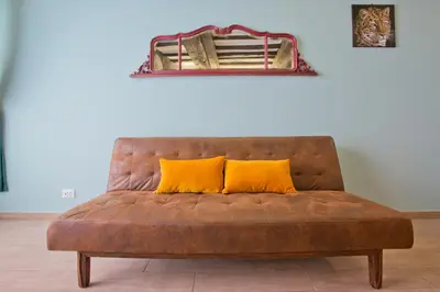 a brown couch with two yellow pillows on it at Il Leopardo (Trastevere) in Rome