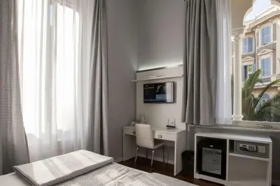 a bedroom with a desk and a bed and a window at Relais Villa Coppedè in Rome