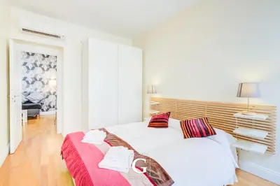 a white bedroom with two beds and a window at Residenza Gonfalone in Rome