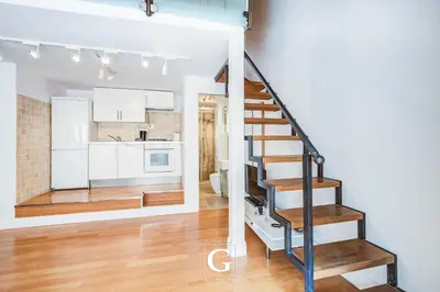 a kitchen and a living room with a staircase in a house at Residenza Gonfalone in Rome