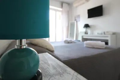 a bedroom with a bed with a blue lamp on a table at Le Cupole in Rome