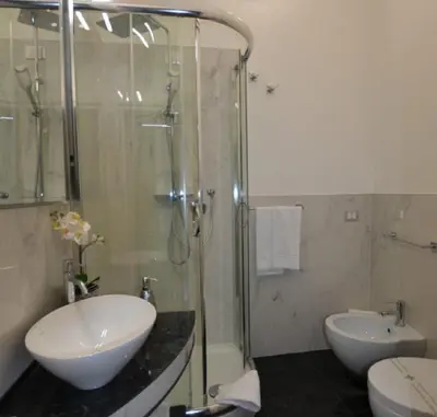 a bathroom with a sink and a glass shower at Il Fascino Di Roma in Rome