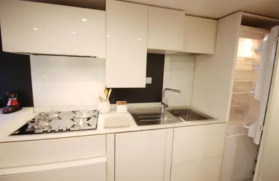 a white kitchen with a sink and a stove at Charm & Design in Gourmet District in Rome