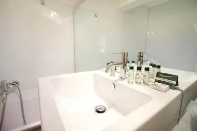 a white bathroom with a sink and a mirror at Charm & Design in Gourmet District in Rome