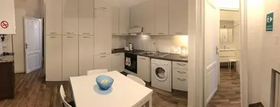 a kitchen with white cabinets and a table with a vase on it at Roma My Home B&B in Rome