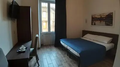 a bedroom with a bed and a table and a window at Roma My Home B&B in Rome