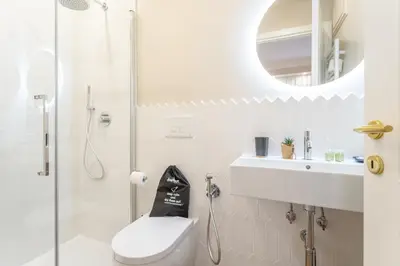 a bathroom with a shower and a toilet and a sink at Rome Central Inn in Rome
