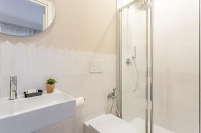 a white bathroom with a sink and a shower at Rome Central Inn in Rome