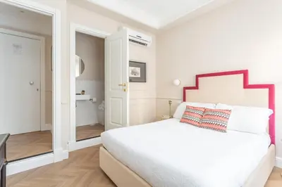a white bedroom with a large bed and a bathroom at Rome Central Inn in Rome