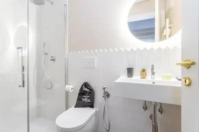 a bathroom with a shower and a toilet and a mirror at Rome Central Inn in Rome