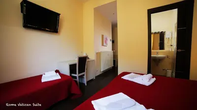 a hotel room with two beds and a tv at Rome Vatican Suite in Rome
