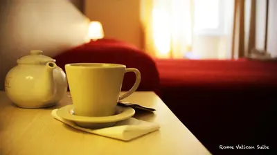 a coffee cup on a table next to a vase at Rome Vatican Suite in Rome