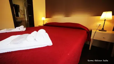 a hotel room with a red bed with towels on it at Rome Vatican Suite in Rome