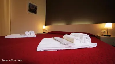 a hotel room with towels and slippers on a bed at Rome Vatican Suite in Rome