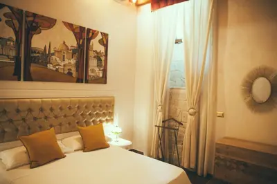 a bedroom with a bed with orange pillows and a window at Lighthouse Suites Trastevere in Rome
