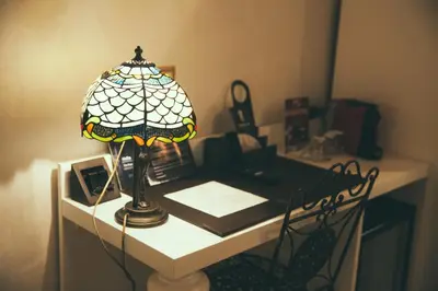 a desk with a lamp and a book on it at Lighthouse Suites Trastevere in Rome