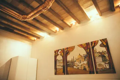 a painting on the wall of a room with a refrigerator at Lighthouse Suites Trastevere in Rome