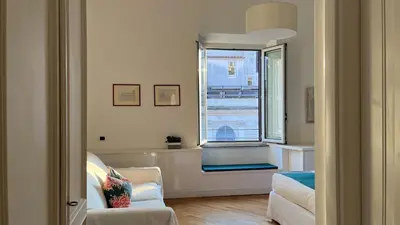 a living room with a chair and a window at NTB Roma B&B in Rome